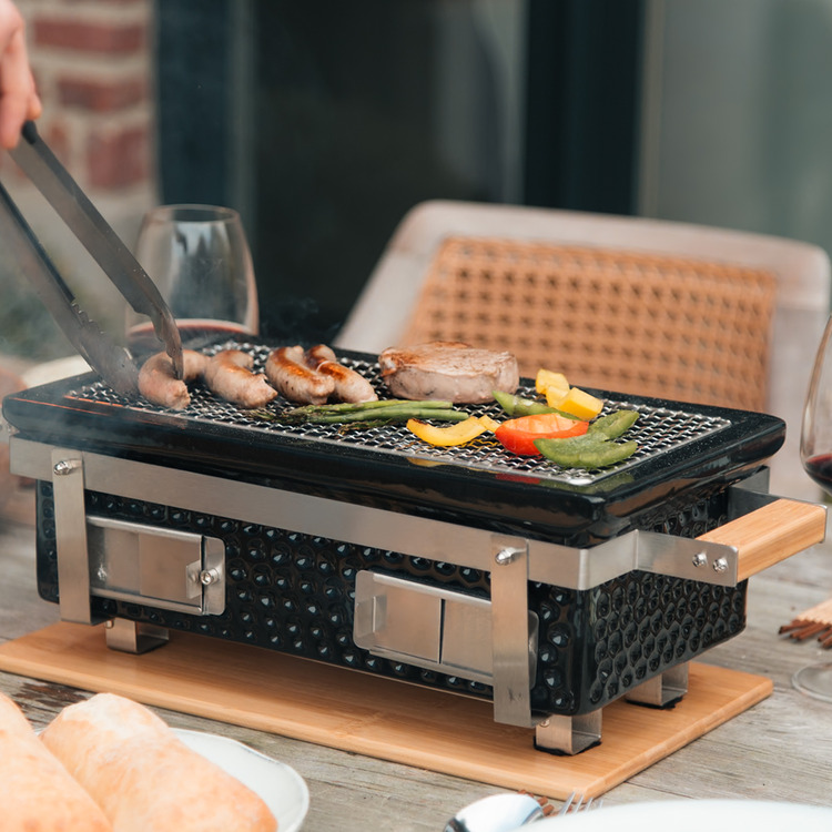 OUTR Braza Table Grill Square in gebruik buiten.