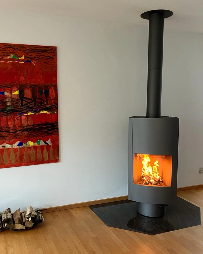 Leenders Hymme houtkachel naast een schilderij